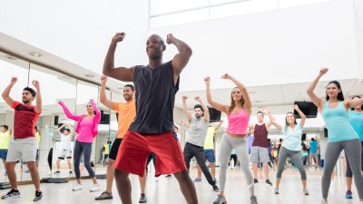 Diverse group of people at a rumba lesson in the gym all looking very happy and smiling